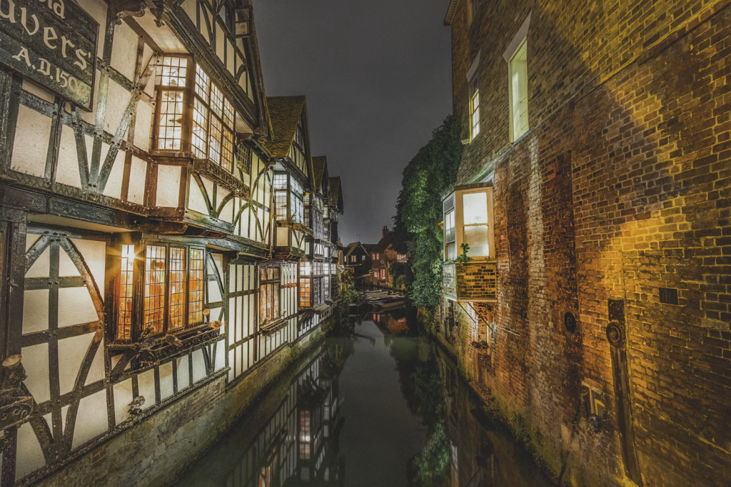 A canal in Canterbury between two buildings at night
